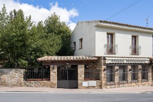 Un restaurante con fachada de piedra, techo de tejas y un letrero que dice