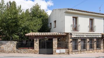 Un restaurante con fachada de piedra, techo de tejas y un letrero que dice 'POSADA RESTAURANTE'.