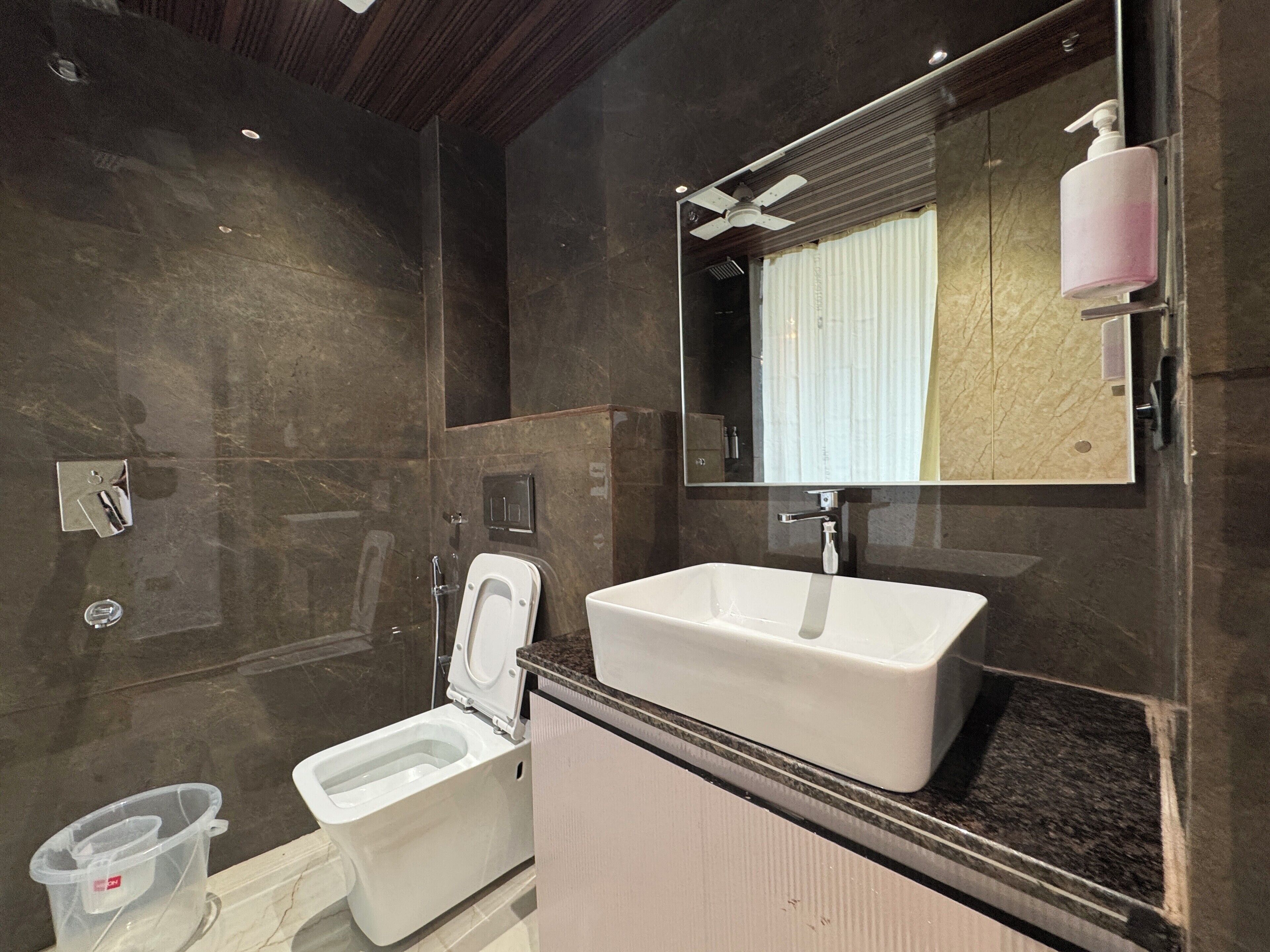 A modern bathroom with a white toilet, a sink, and a mirror.