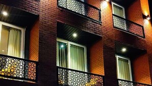 A hotel named "Ganga Aamantar" with a brick facade, multiple balconies with decorative railings, and a visible reception area with a sign indicating it is a hotel. - Hotel Ganga Aamantran (Haridwar)