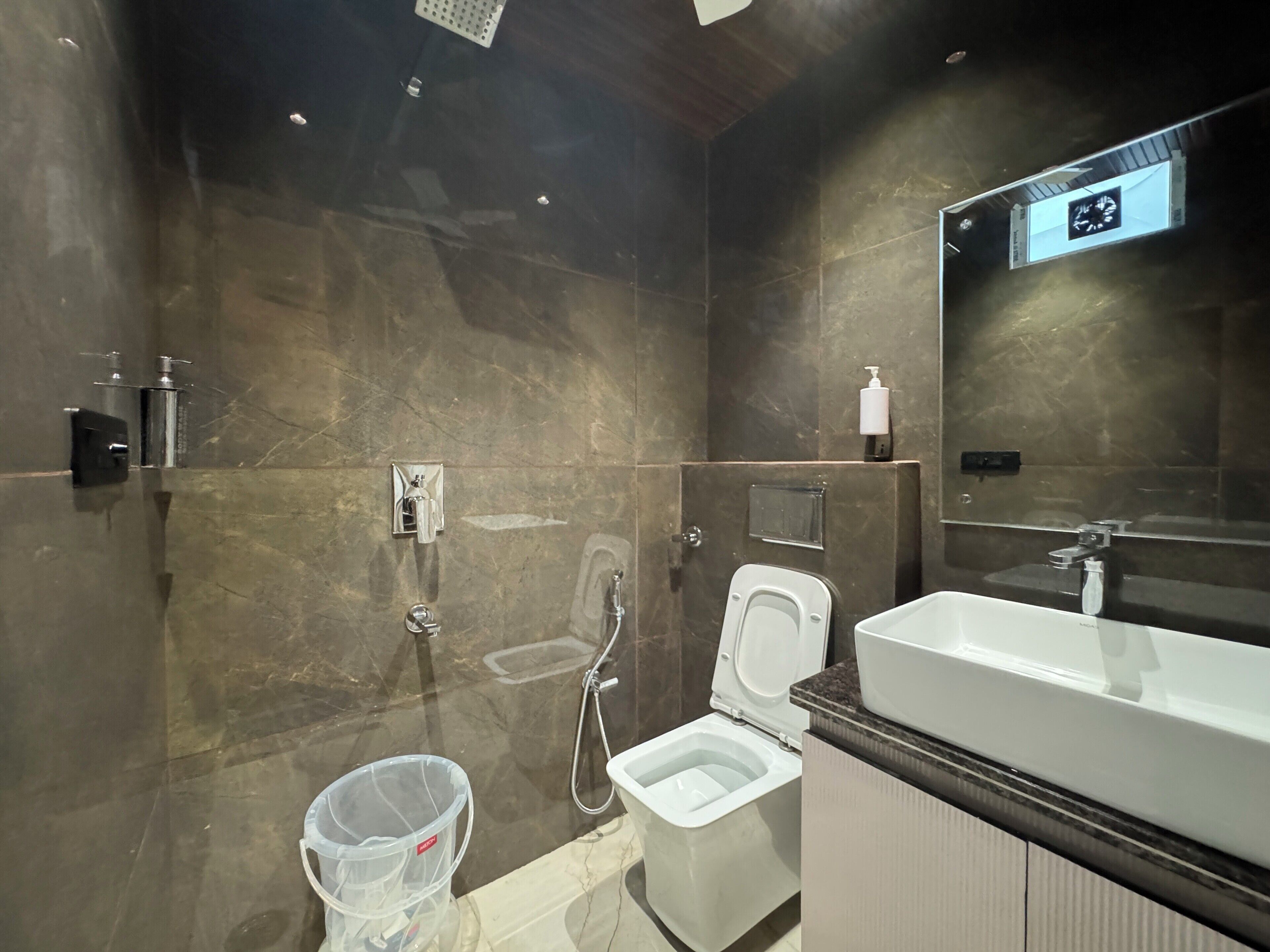 A modern bathroom with a toilet, bidet, and a large mirror.
