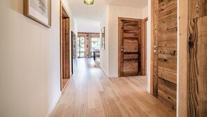 A hallway with wooden doors and a ceiling light fixture.