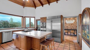 A spacious kitchen with a large island, wooden cabinets, and a stone backsplash. - Catalina Dreamin' Luxe Foothills Oasis w/Pool! (Tucson)