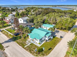 A residential area with houses, a paved road, and a body of water in the background. - Crescent Beach Cottage | Dog-Friendly (St. Augustine)