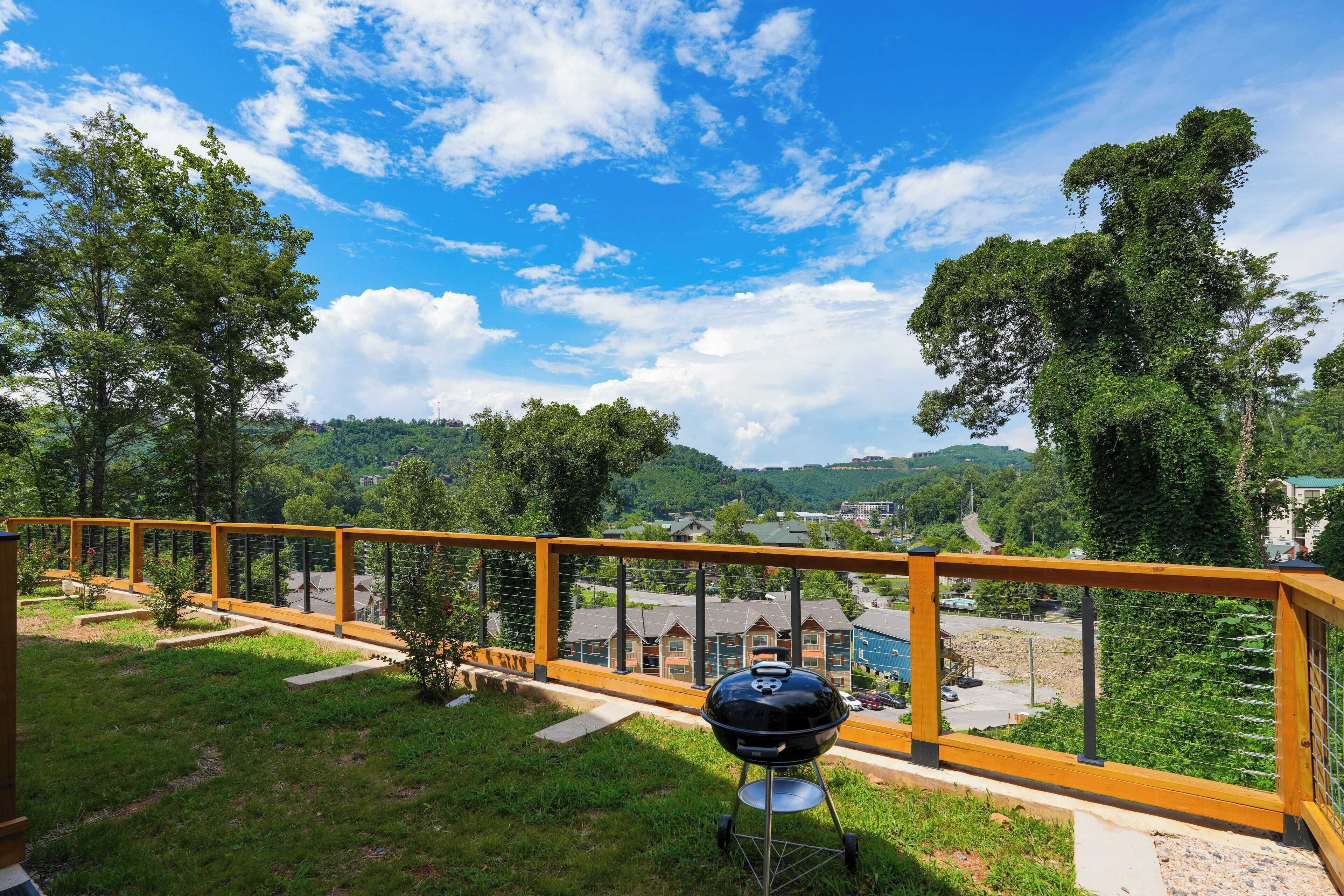Ein Balkon mit Blick auf eine Stadt, einem Grill und einem gelben Geländer.