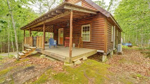 Eine Blockhütte mit Veranda, Holzstufen und einer kleinen Außenterrasse.