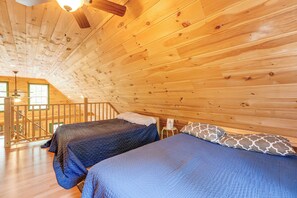 Een chalet met twee bedden, houten wanden, een balkon en een houten plafond.