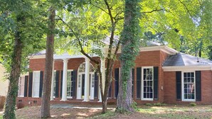 A brick building with large windows and a covered porch. - Welcoming 4-bedroom house in vibrant Buckhead Atlanta (Atlanta)
