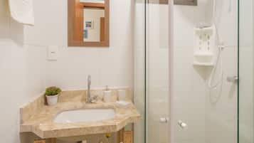 Un baño con lavamanos, espejo y ducha.