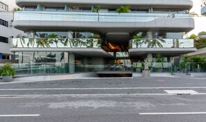 A modern building with a unique architectural design featuring a central atrium and multiple balconies.