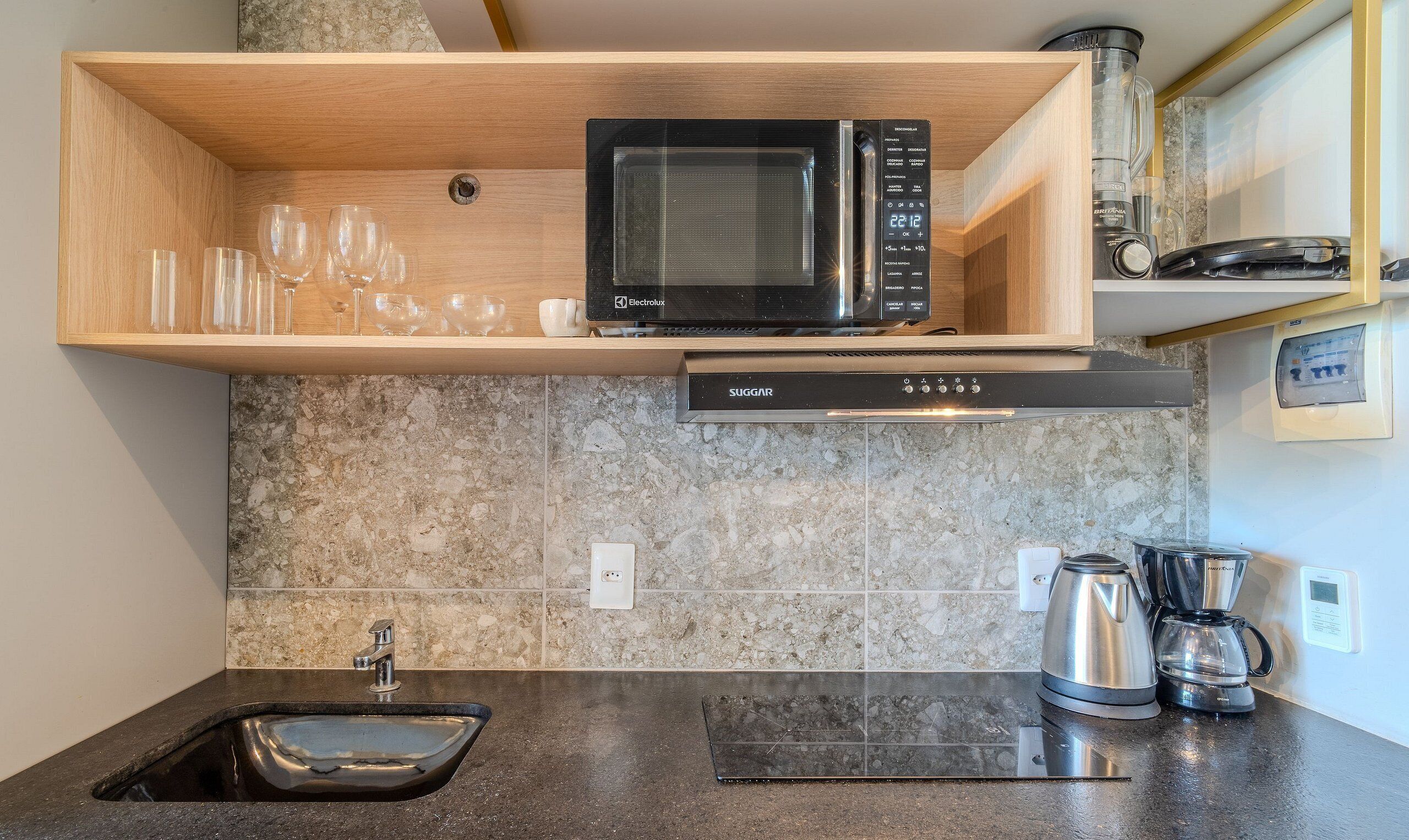 Una cocina equipada con microondas, cafetera y lavabo.