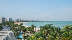 A resort with a beach view, multiple pools, and palm trees.