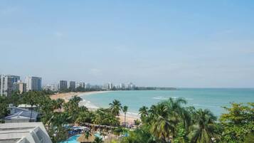 Un resort con vista a la playa, varias piscinas y palmeras.
