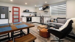 A compact living space with a kitchenette, a dining area with a wooden table and benches, a sofa, and a coffee table. - Chic Downtown Steamboat Condo – Walk to Prime Spots (Steamboat Springs)