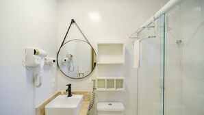 A modern bathroom with a sink, mirror, and glass shower enclosure. - Cozy Studio in Praia do Forte Vgc0005 (Mata de São João)