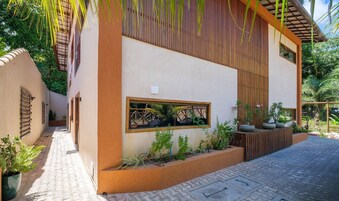 Un edificio moderno con fachada color beige, listones de madera y un ventanal pequeño.