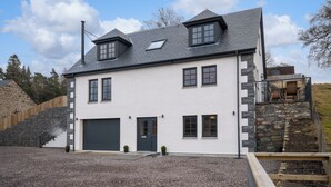 Een herenhuis met een stenen gevel, een garage en een klein terras.