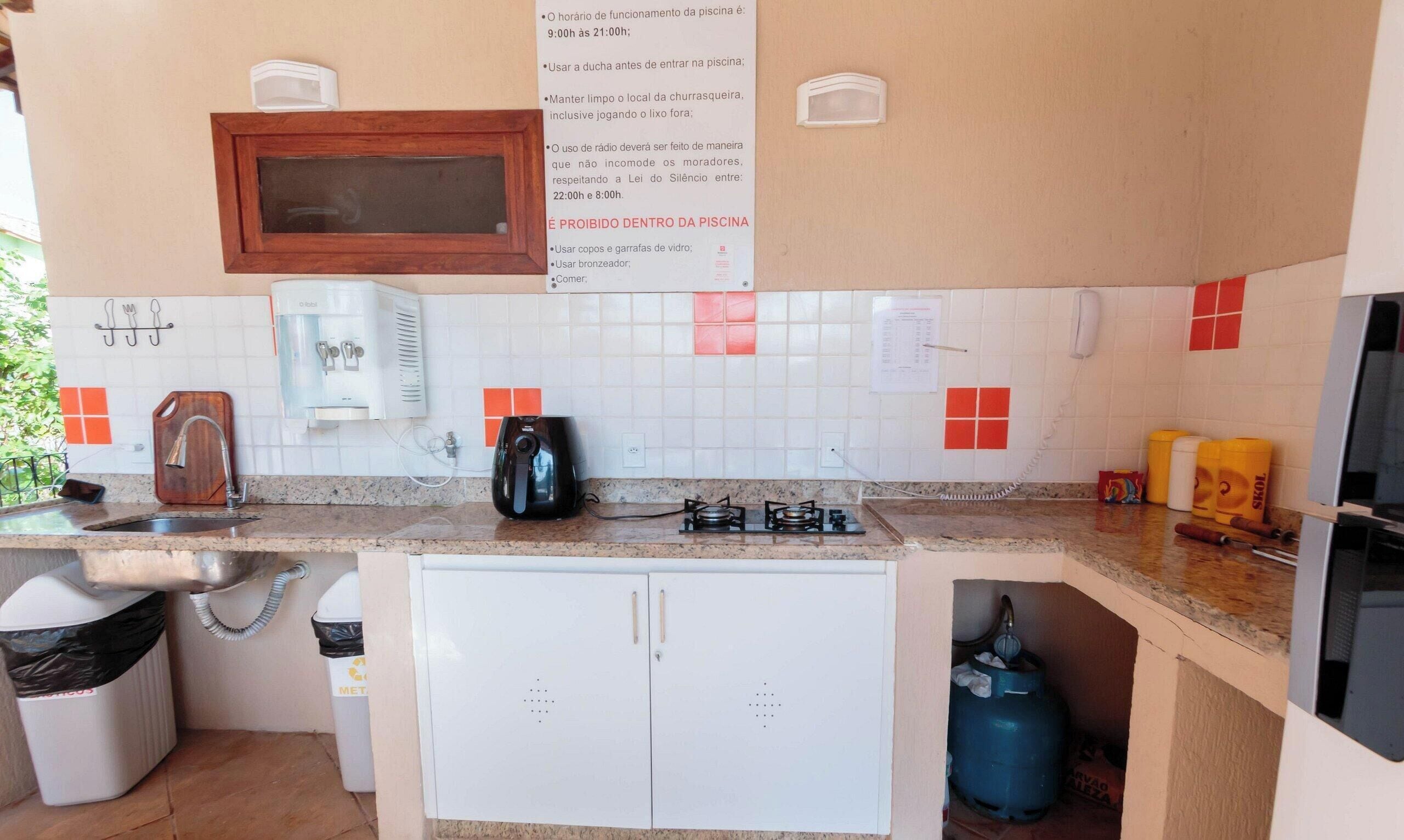 Cocina pequeña con fregadero, estufa y dispensador de agua.