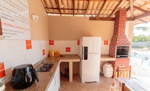 Eine kleine Küche mit Kühlschrank, Gasherd und Backofen.