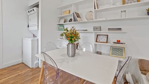 A modern kitchen with white cabinetry, a built-in oven, and a white dining table with chairs. - Spacious Modern Home near Ocean Resort + Boardwalk (Atlantic City)