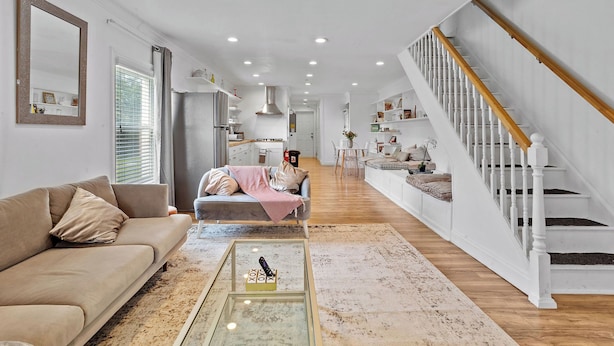 A spacious living area with a sofa, a coffee table, and a staircase. - Spacious Modern Home near Ocean Resort + Boardwalk (Atlantic City)
