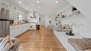 A modern kitchen with white cabinetry, a stainless steel refrigerator, and a wooden countertop. - Spacious Modern Home near Ocean Resort + Boardwalk (Atlantic City)