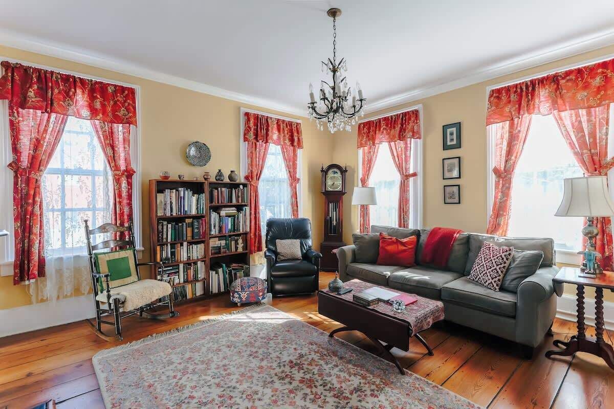 A cozy living room with a sofa, armchair, and a bookshelf.