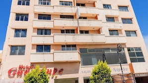A multi-story hotel with balconies, a visible salon, and a sign for 'Hotel Guadalupe'. - Hotel Guadalupe Express (Guadalupe)