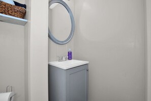 A bathroom with a white sink, a mirror, and a towel rack. - Cozy Room & Private Bath Near VA Medical Center (Fayetteville)