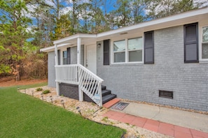 A two-story house with a covered porch and a small front yard. - Cozy Room & Private Bath Near VA Medical Center (Fayetteville)