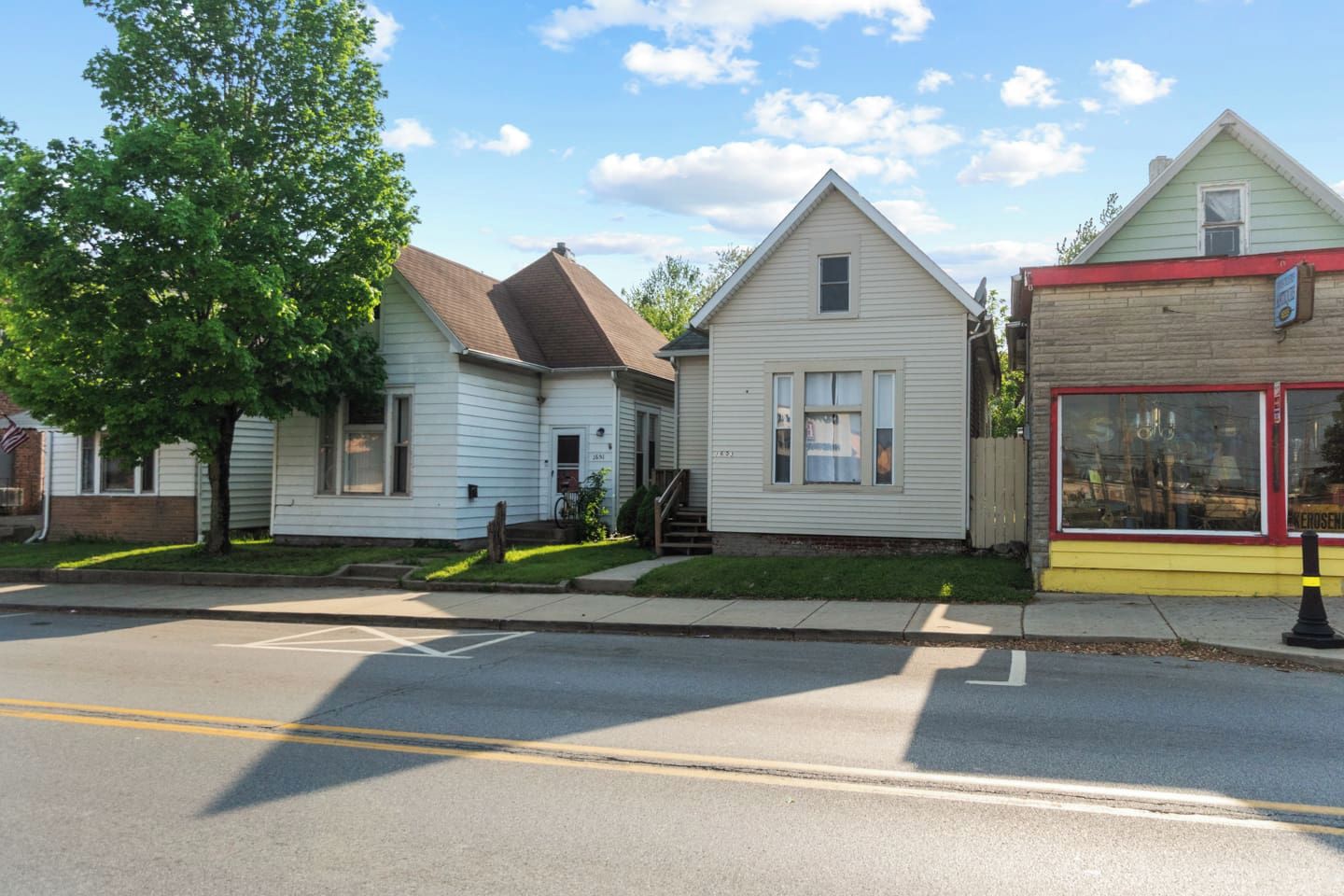 A row of residential houses with a clear street in front.