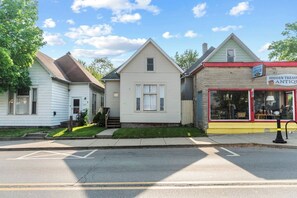 Une rangée de maisons avec une devanture de magasin bien visible sur la droite.