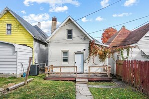 Ein Wohnhaus mit Veranda, Garage und umzäunter Garten.