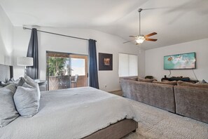A bedroom with a bed, a ceiling fan, a TV, and a view of the outside. - Spacious Escape | Pool, Hot Tub & Room for Up to 14 Guests (Scottsdale)