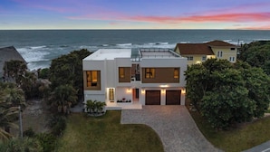 Een modern herenhuis met garage, gelegen op een heuvel met uitzicht op de oceaan.
