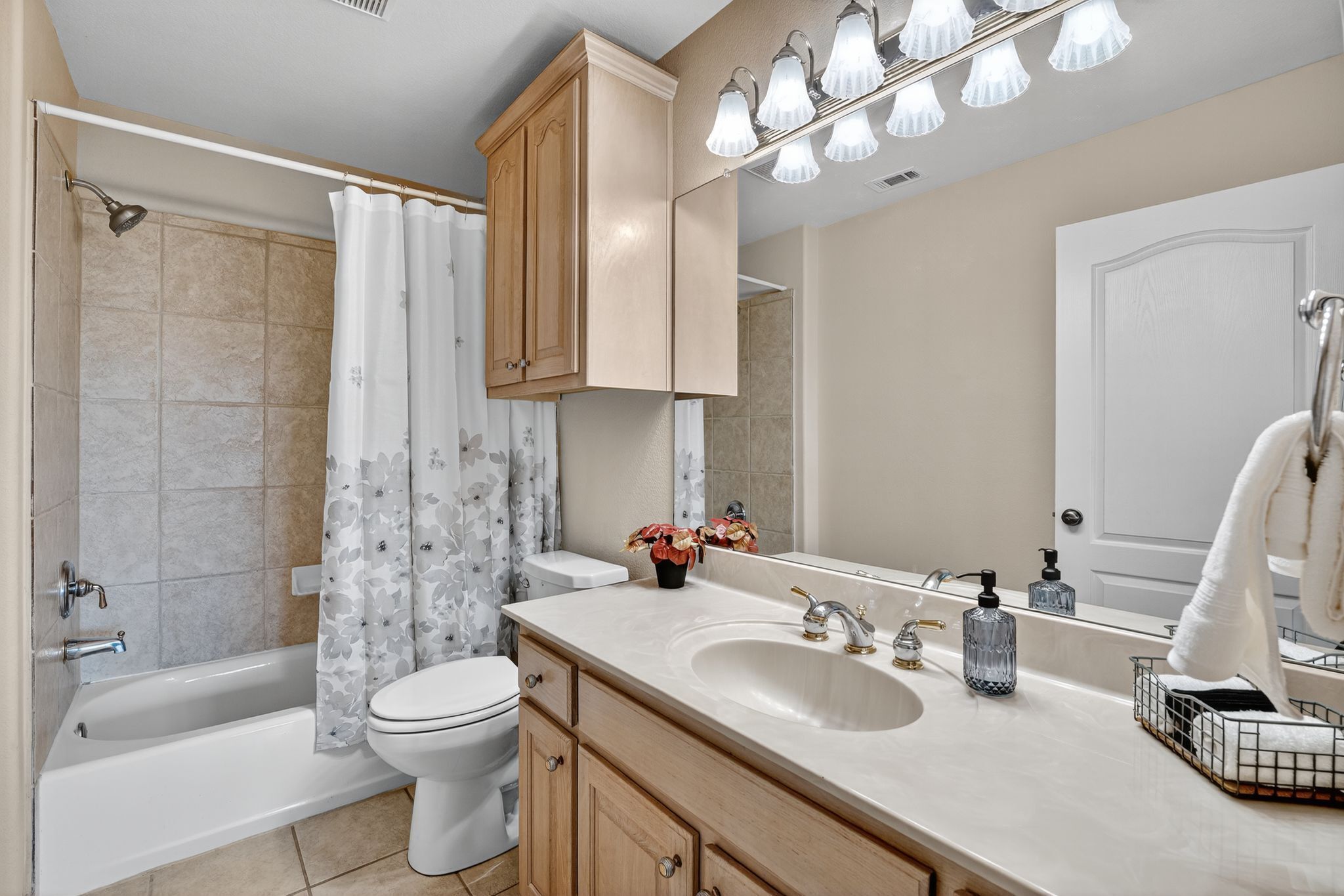 A bathroom with a bathtub, toilet, sink, and mirror.