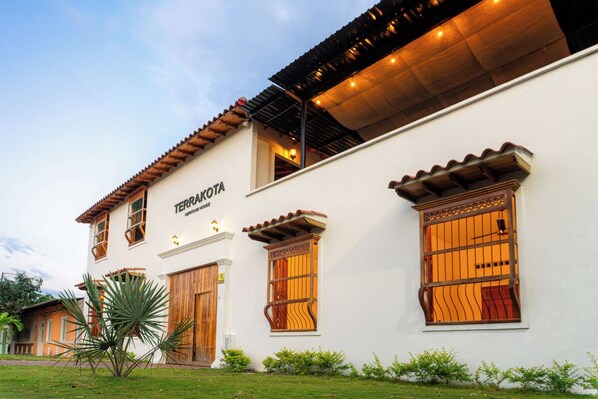 A white building with the sign "TERRAKOTA" and a wooden door.