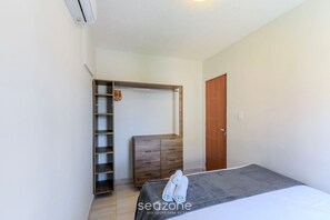 A bedroom with a bed, a wardrobe, and a built-in closet.