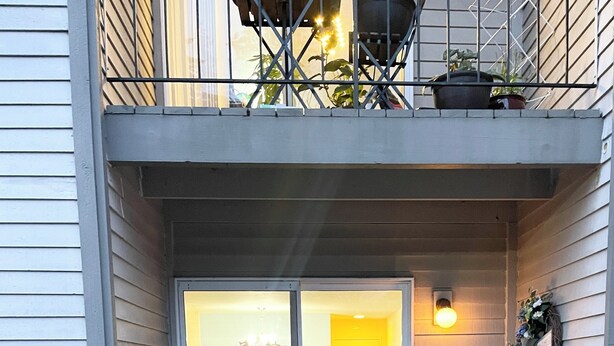 Eine überdachte Terrasse mit einer Schiebetür, die in einen Innenbereich mit Essbereich führt.