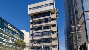 Ein mehrgeschossiges Gebäude mit moderner Architektur, mit Balkonen und großen Fenstern.