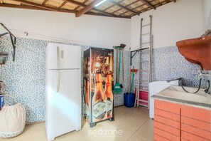 Una cocina equipada con refrigerador, lavadora, pileta y salpicadero de cerámica.