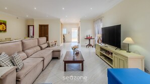 A living room with a sofa, a coffee table, a TV, and a lamp. - House w/ Pool 350 m From Taperapuan Beach Rud0047 (Porto Seguro)