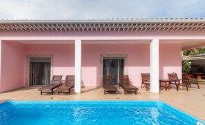 A poolside area with lounge chairs and a pool.