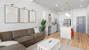 Eine moderne Wohnung mit Wohnzimmer, Küchenzeile und Essbereich.