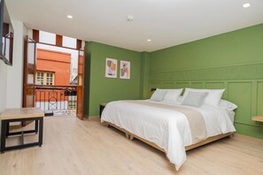 Une chambre avec un lit, une petite table et une vue sur un espace extérieur.