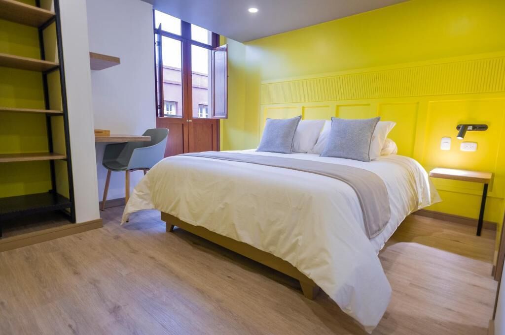 Ein Schlafzimmer mit Bett, Schreibtisch und Stuhl.
