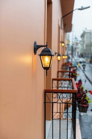 Une rangée de lampes extérieures fixées au mur, le long de la façade d’un bâtiment.