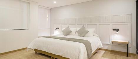 Een moderne slaapkamer met een bed, nachtkastjes en een hoofdbord.