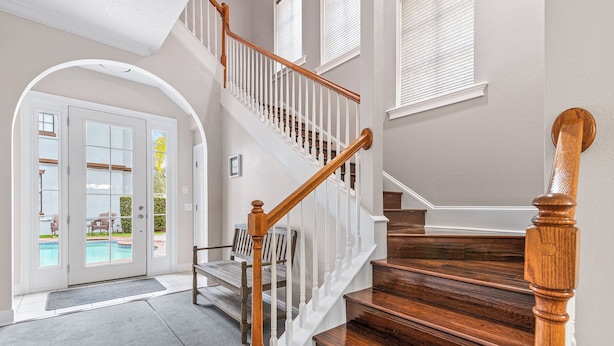 A staircase with wooden railings and a view of a pool outside. - Inviting 5BR Villa in Reunion Resort (Kissimmee)
