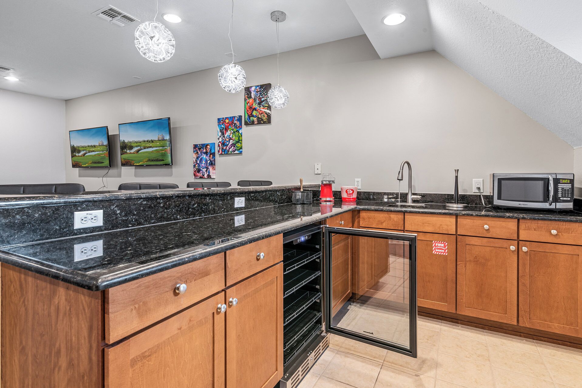 A modern kitchen with granite countertops, wooden cabinets, a built-in oven, and a microwave.